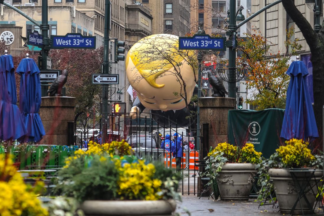 Boss Baby ballon seen between the greenery by the Herald Square park